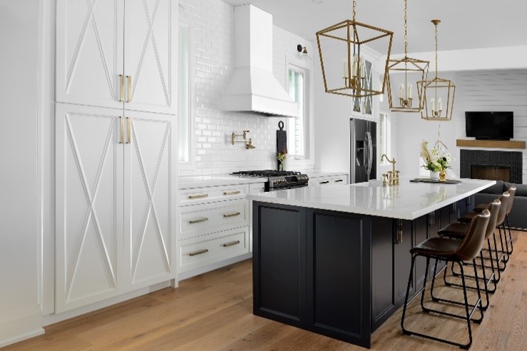 Kitchen renovation with white island and dark cabinets in "Modern Makeover" by RenoMark Member Reborn Renovations, Finalist in the 2021 CHBA National Awards for Housing Excellence.