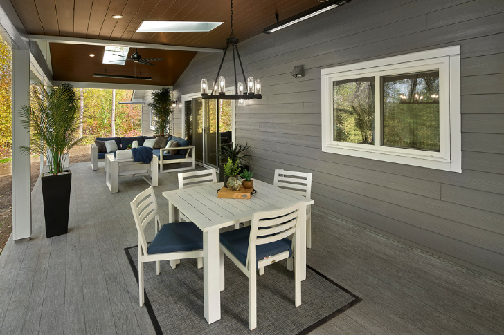 Back deck under overhanging ceiling with two seating areas.