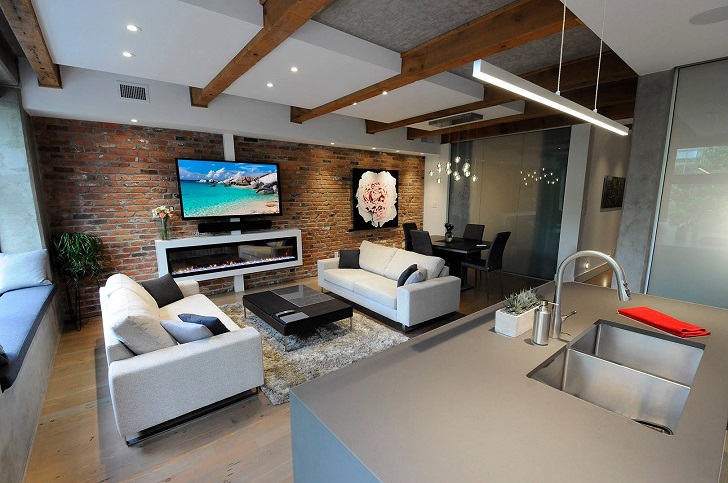 Glamorous condo renovation with exposed brick and modern furniture.
