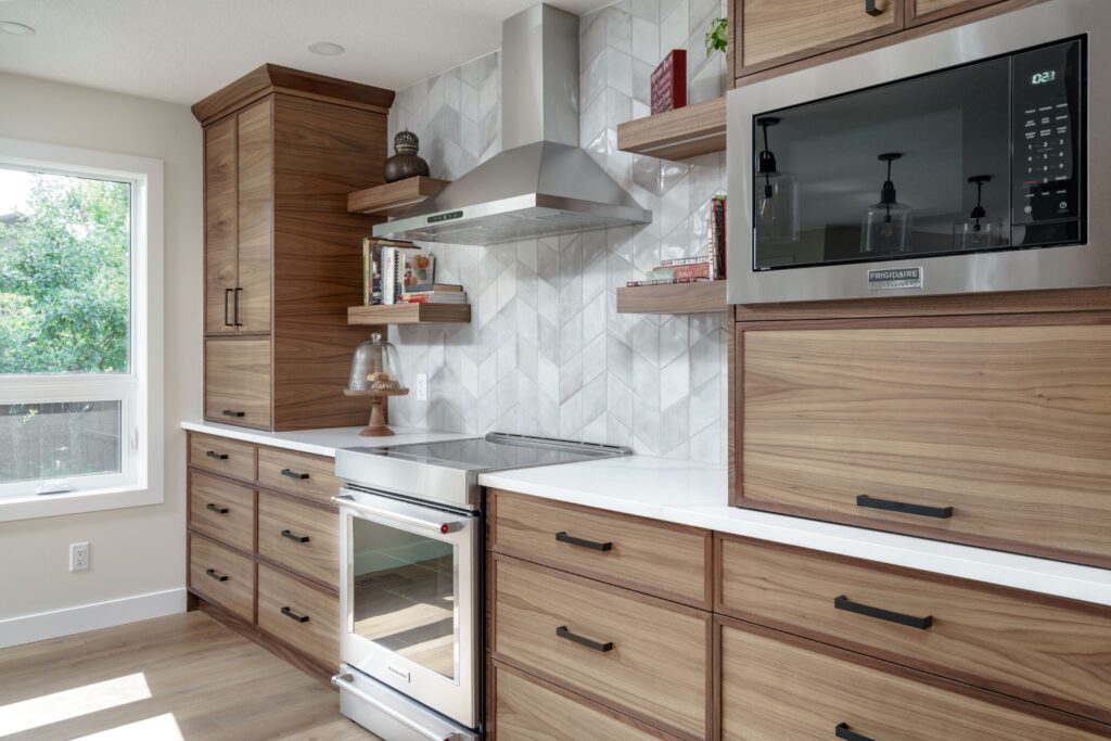 Modern kitchen with wood cabinets, white countertops, a built-in microwave, stainless steel stove and range hood, open shelving with decor, and a large window letting in natural light.
