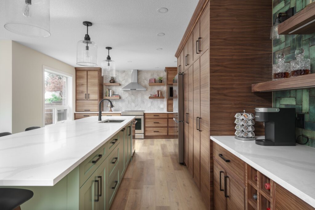 Modern kitchen with wooden cabinets, green island with white countertop, built-in appliances, a coffee machine, and open shelving with green tile backsplash. Large window lets in natural light.