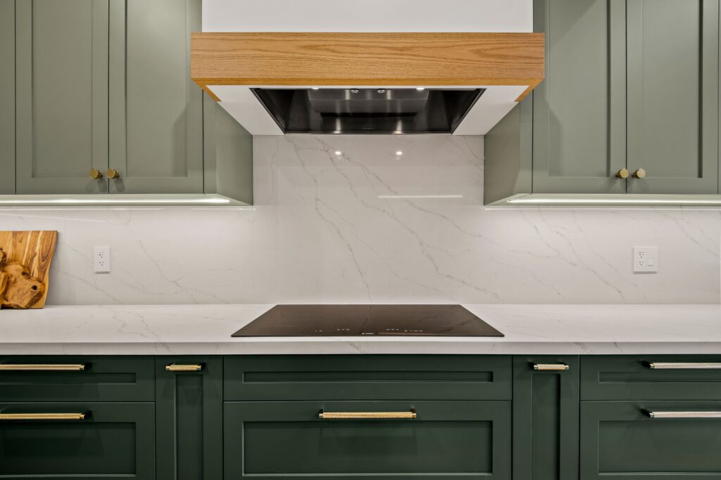 open concept green kitchen with integrated hood