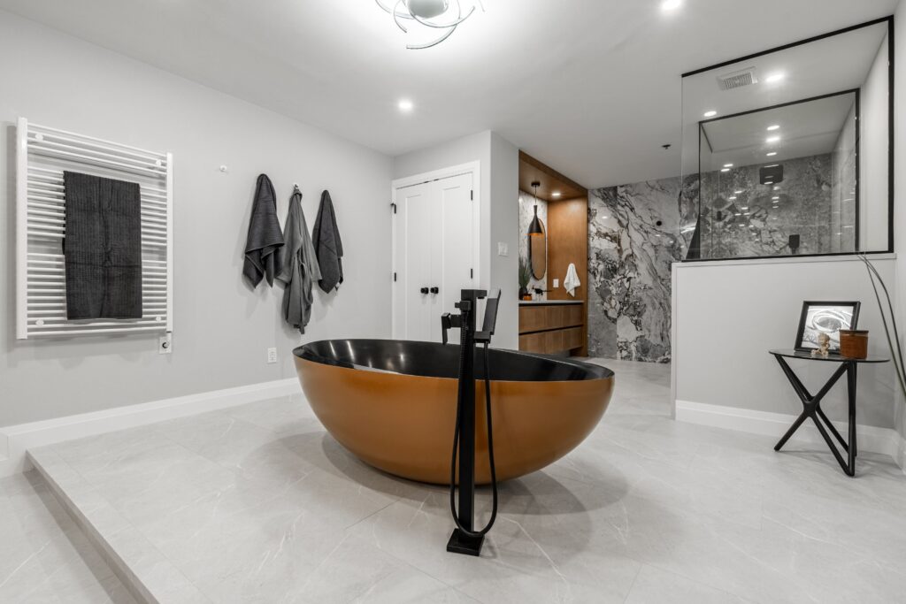 Freestanding tub as a sculpture under geometric chandelier
