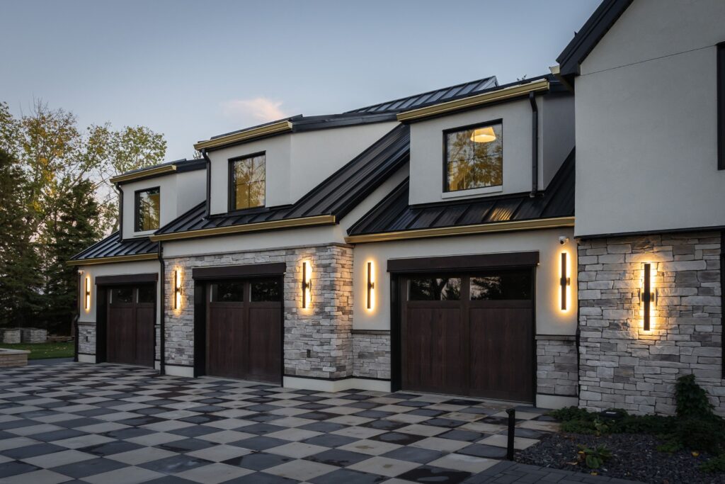The expansive exterior of a remodelled modern Tudor home, with integrated living space above the triple garage, reflecting personal style and functionality