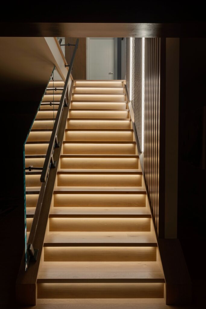 LED strip lighting under stairs enhances basement ambiance.