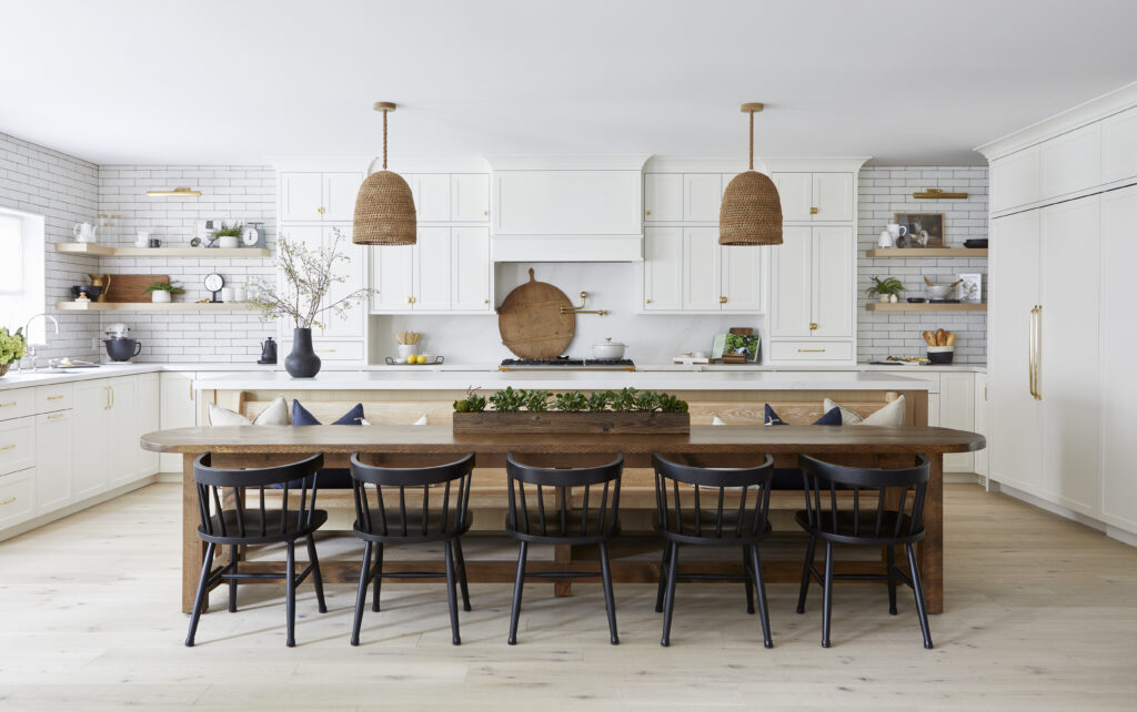 A kitchen with a long table and chairs.