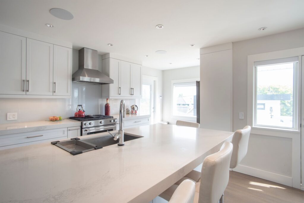 A kitchen with white cabinets and a large island.