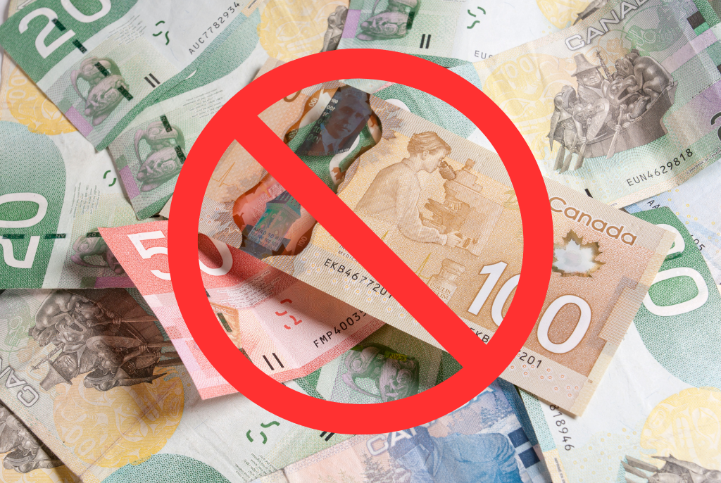 A pile of Canadian banknotes with a large red prohibition symbol over them, indicating a ban or restriction on the use of Canadian cash.